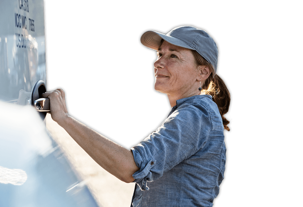 Female caucasian truck driver getting into her truck