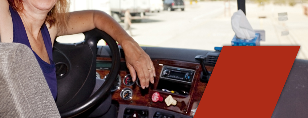 woman truck driver at wheel wondering if truck driving schools teach manual