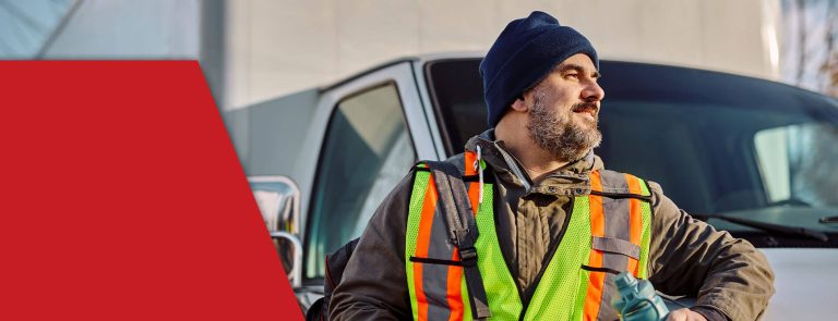 man that has skills for new truck driver posing by truck in safety gear
